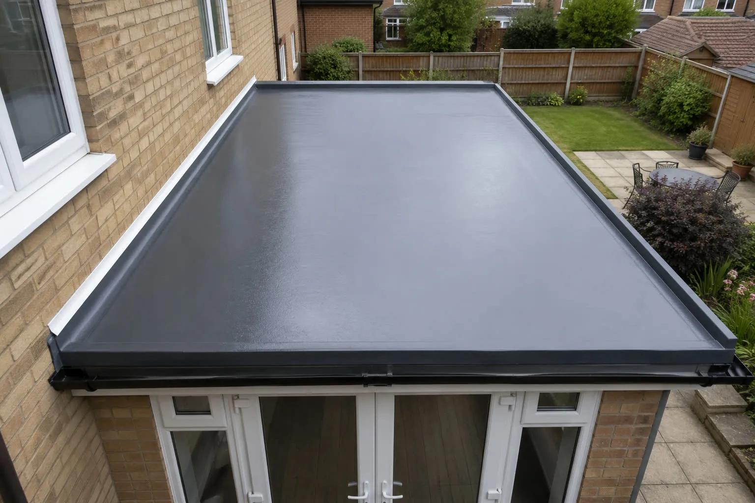 A newly laid grey GRP flat roof on a single-storey rear extension