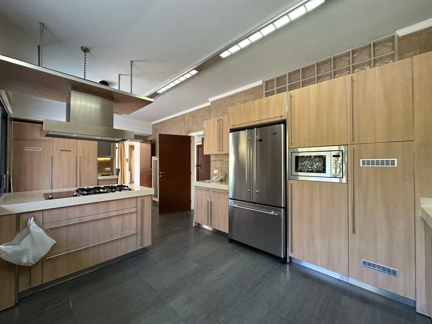 Contemporary kitchen renovation with wooden cabinetry and stainless appliances in Reigate