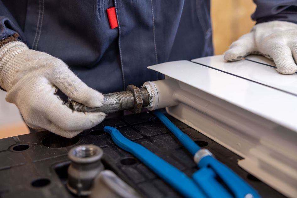 Swift Plumbing engineer installing a radiator